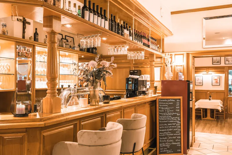Holzbar mit Weinregal, Barsesseln und Kreidetafel im Restaurant Am Park