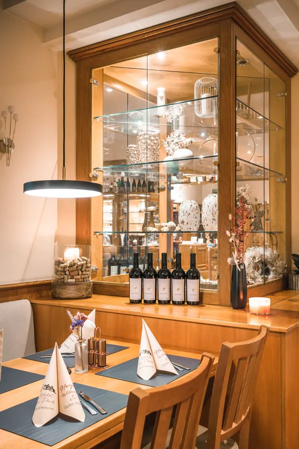 Beleuchtete Vitrine mit Weinflaschen und Dekoration im Restaurant